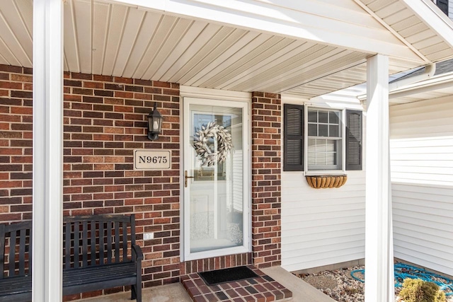 doorway to property with brick siding