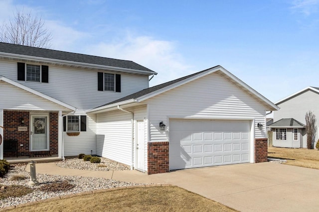 traditional-style home with brick siding, an attached garage, and driveway