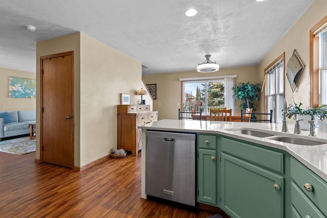 kitchen featuring green cabinetry, dark wood-style flooring, a sink, light countertops, and stainless steel dishwasher