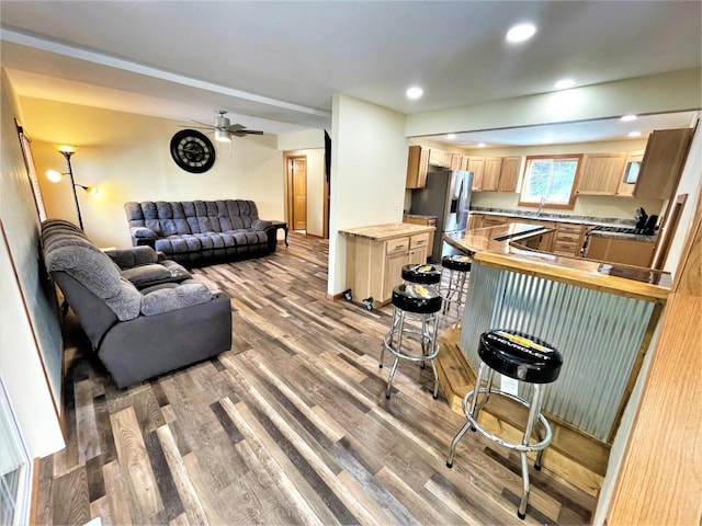 living room with a ceiling fan, recessed lighting, and wood finished floors