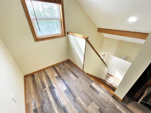 stairs featuring vaulted ceiling, baseboards, and wood finished floors