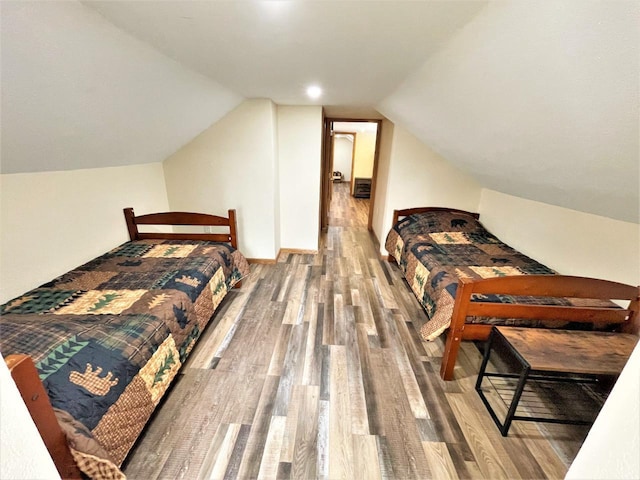 bedroom with wood finished floors and vaulted ceiling