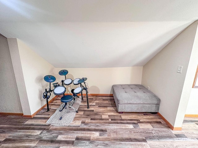 living area with lofted ceiling, wood finished floors, and baseboards