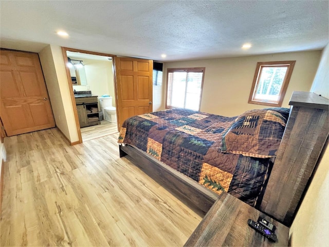 bedroom featuring recessed lighting, a textured ceiling, ensuite bath, and light wood-style flooring