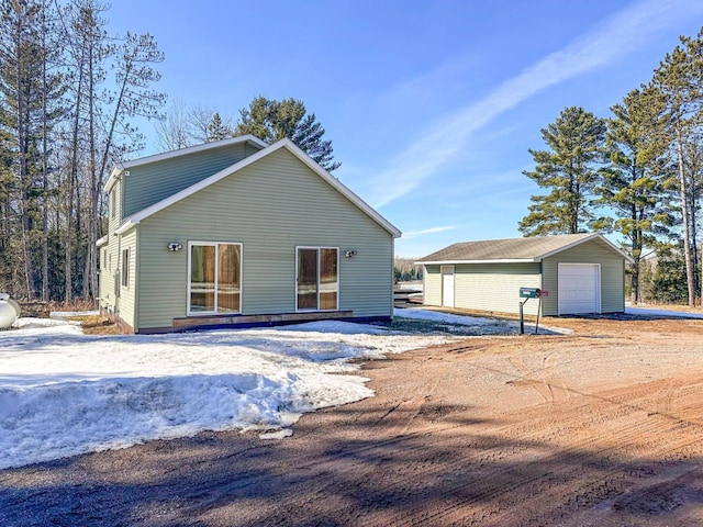 exterior space with an outbuilding and a detached garage