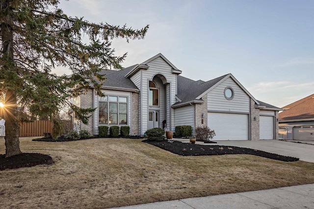 view of front of property featuring brick siding, an attached garage, fence, a front yard, and driveway