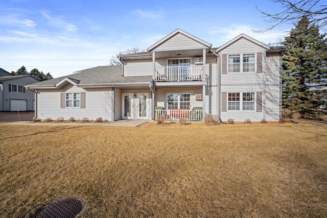 view of front of house with a balcony, a porch, and a front lawn