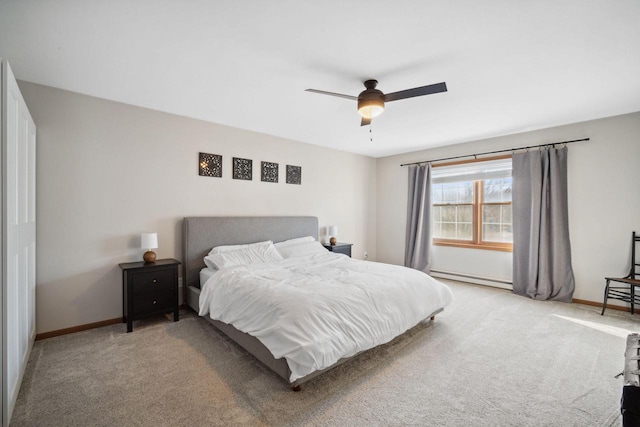 bedroom with light carpet, a baseboard heating unit, and baseboards