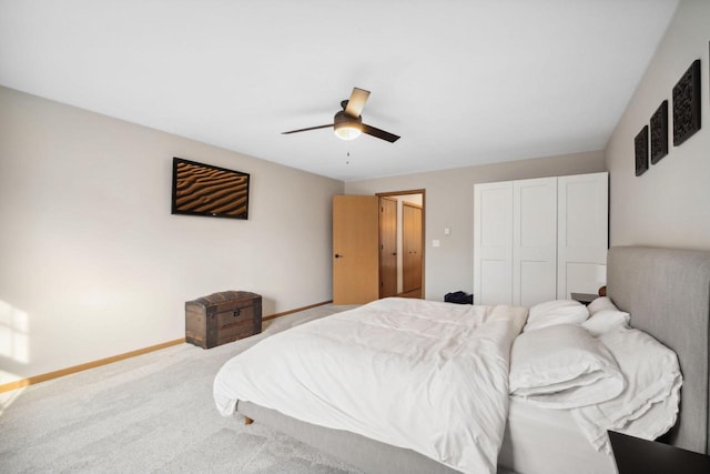 carpeted bedroom with baseboards, a closet, and ceiling fan