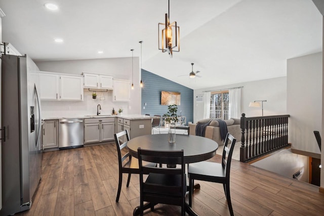 dining area featuring dark wood finished floors, vaulted ceiling, recessed lighting, and ceiling fan