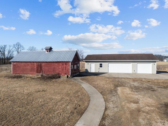 view of front facade featuring an outbuilding, a garage, and metal roof