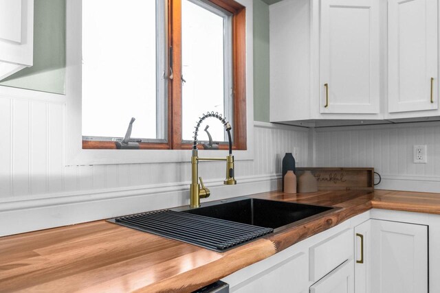 kitchen featuring white cabinets and a sink