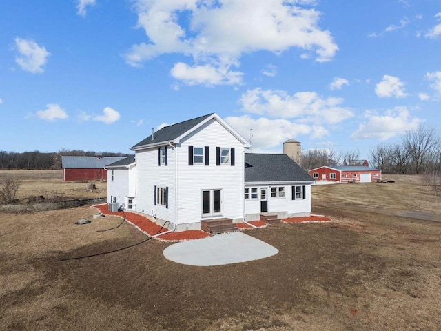 view of front of property featuring a chimney, entry steps, a shingled roof, and a front lawn