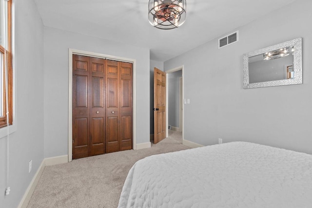 bedroom with visible vents, carpet floors, baseboards, and a closet