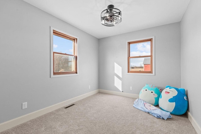 interior space with carpet flooring, visible vents, and baseboards