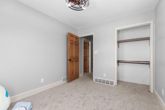 unfurnished bedroom featuring visible vents, baseboards, carpet, and a closet