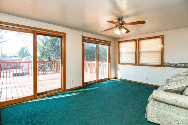 carpeted living room with a ceiling fan and baseboards