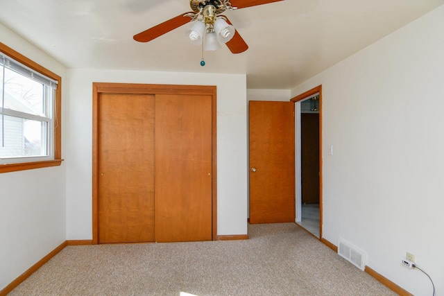 unfurnished bedroom featuring a closet, visible vents, baseboards, and carpet