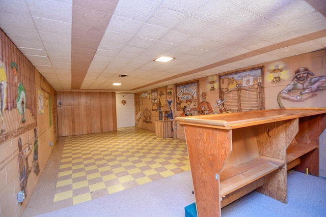 bar featuring light floors, a dry bar, and wood walls