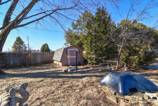 view of yard with an outbuilding, a fenced backyard, and a shed