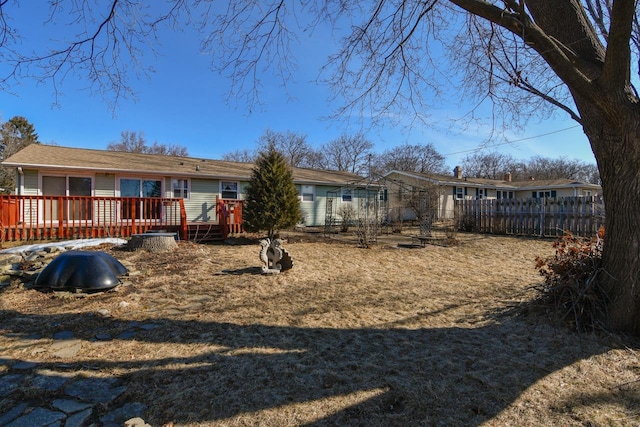 rear view of house with a wooden deck and fence