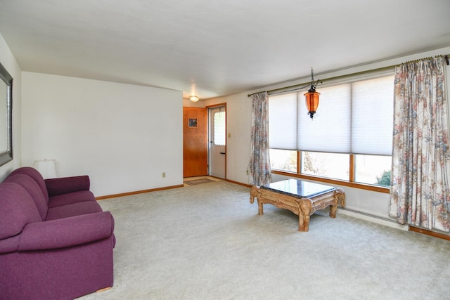 carpeted living room featuring a baseboard heating unit and baseboards