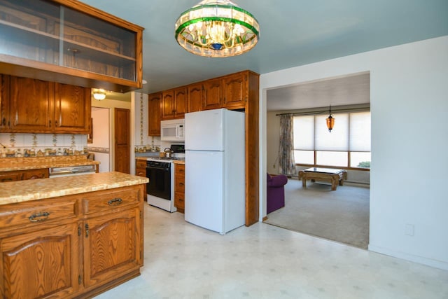 kitchen featuring white appliances, pendant lighting, brown cabinetry, and light countertops