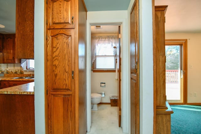 bathroom with visible vents, baseboards, toilet, tile patterned floors, and a sink