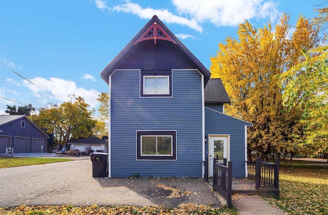 view of front of house featuring a deck, a garage, and roof with shingles