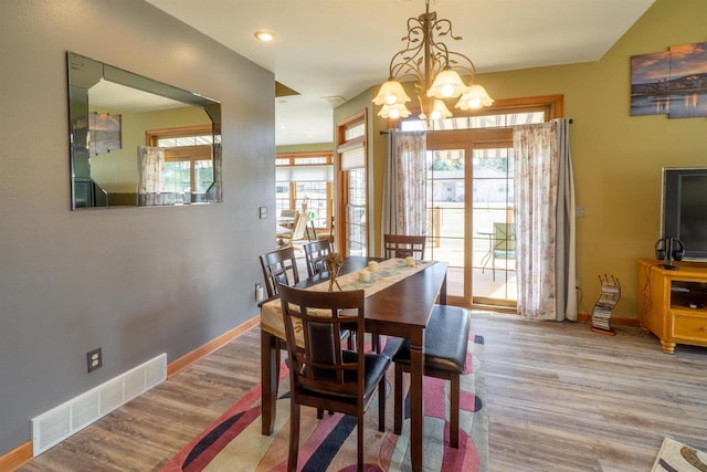 dining room featuring visible vents, a healthy amount of sunlight, and wood finished floors