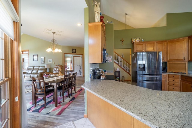 kitchen with a notable chandelier, light stone counters, plenty of natural light, and stainless steel appliances