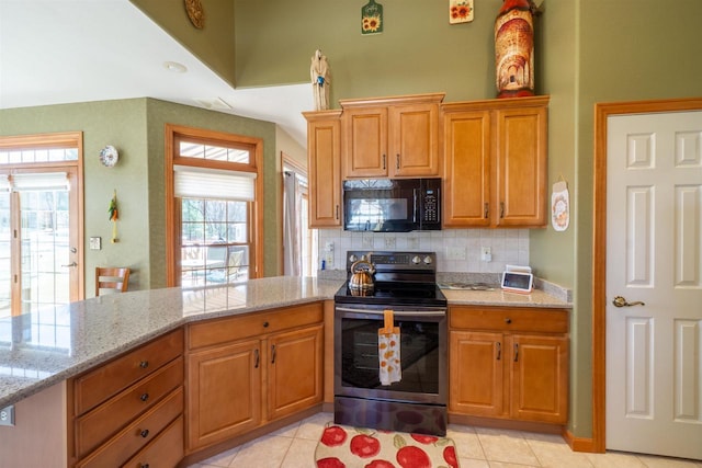 kitchen with light stone counters, stainless steel electric range oven, tasteful backsplash, and black microwave