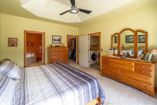 bedroom featuring ensuite bath, a spacious closet, a closet, washer and dryer, and light colored carpet