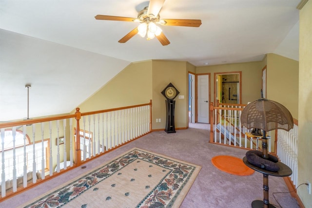 hallway featuring vaulted ceiling, an upstairs landing, baseboards, and carpet floors