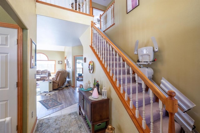 stairs featuring tile patterned flooring and a high ceiling