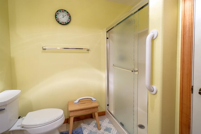 full bathroom featuring tile patterned floors, a shower stall, toilet, and baseboards