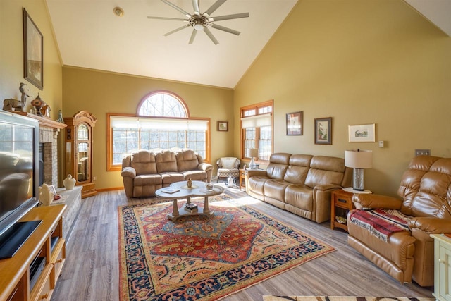 living area featuring baseboards, high vaulted ceiling, a ceiling fan, and wood finished floors