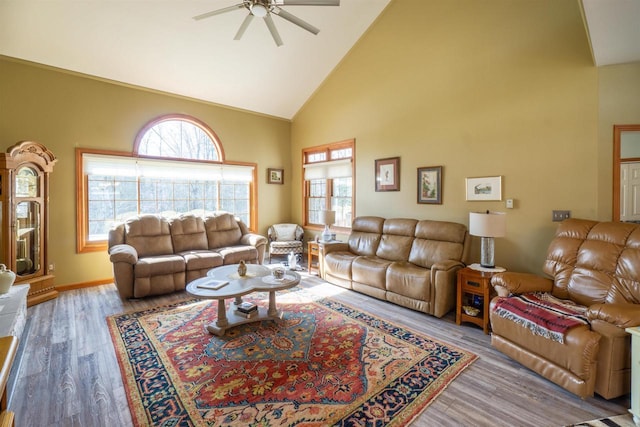 living room featuring ceiling fan, wood finished floors, baseboards, and high vaulted ceiling