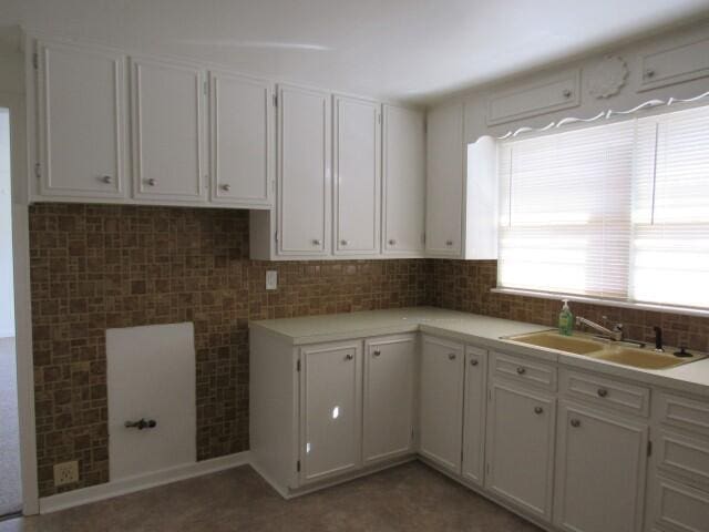 kitchen featuring a sink, white cabinets, and light countertops