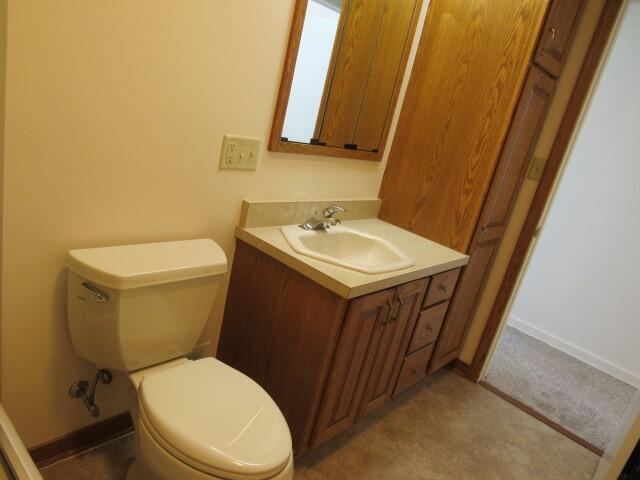 bathroom featuring baseboards, toilet, and vanity