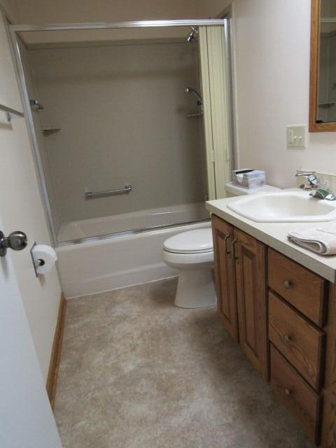 bathroom featuring toilet, vanity, and bathtub / shower combination