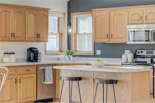 kitchen with a sink, appliances with stainless steel finishes, light brown cabinetry, and light countertops