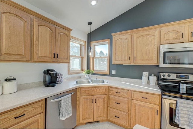 kitchen featuring light brown cabinetry, a sink, stainless steel appliances, light countertops, and lofted ceiling