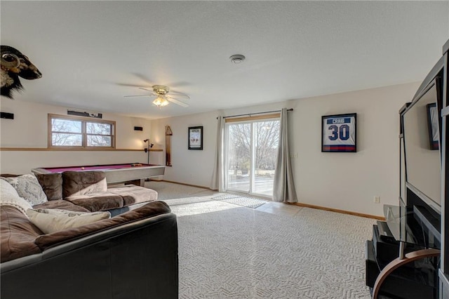 living area featuring a wealth of natural light, visible vents, light carpet, and baseboards