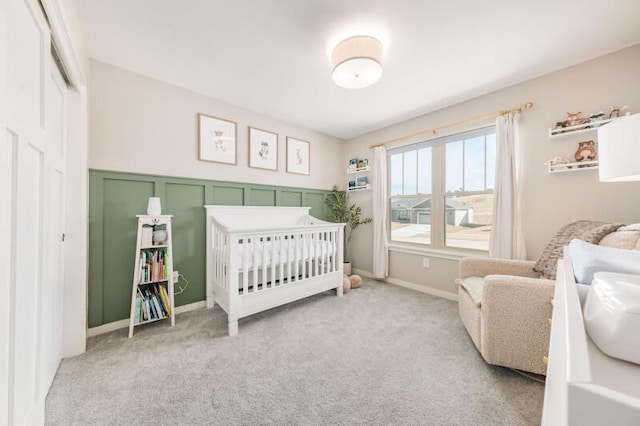 carpeted bedroom with a closet, a decorative wall, and a crib