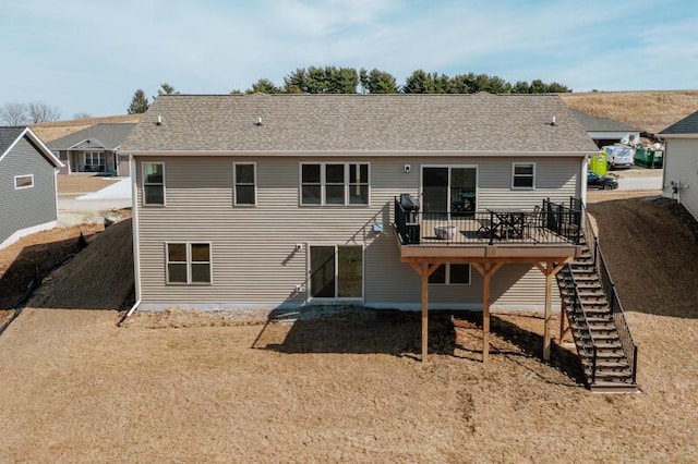 rear view of house featuring a wooden deck, stairs, and a shingled roof