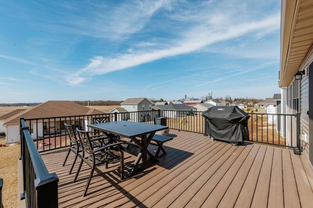 wooden deck with a residential view, a grill, and outdoor dining area