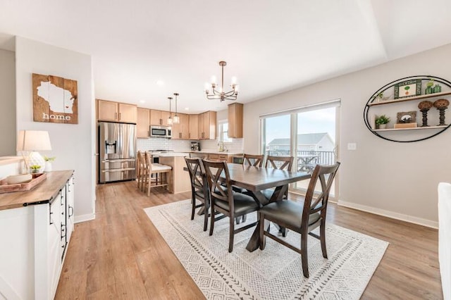 dining room with light wood-style flooring, recessed lighting, baseboards, and a chandelier