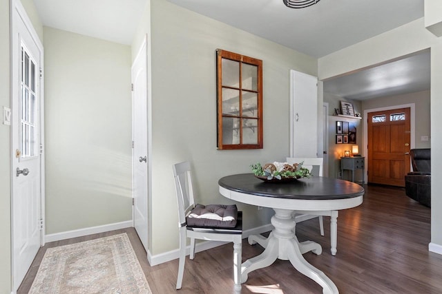 dining space with wood finished floors and baseboards