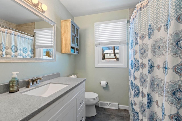 bathroom with vanity, baseboards, visible vents, tile patterned floors, and toilet